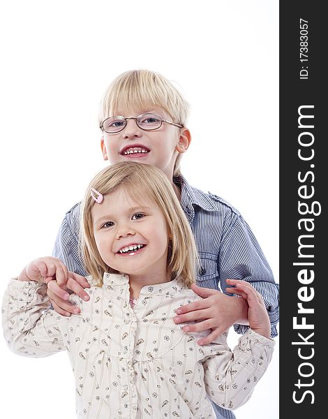 Children - portrait of brother and sister standing, holding each other - isolated on white