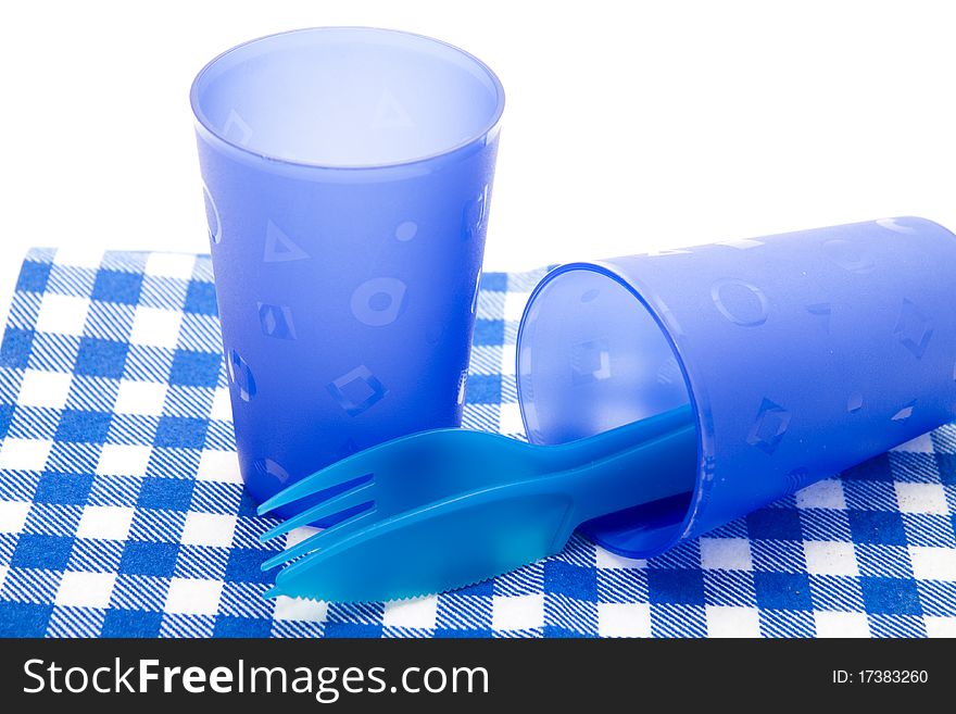 Blue cups and cutlery on blue white table cloth