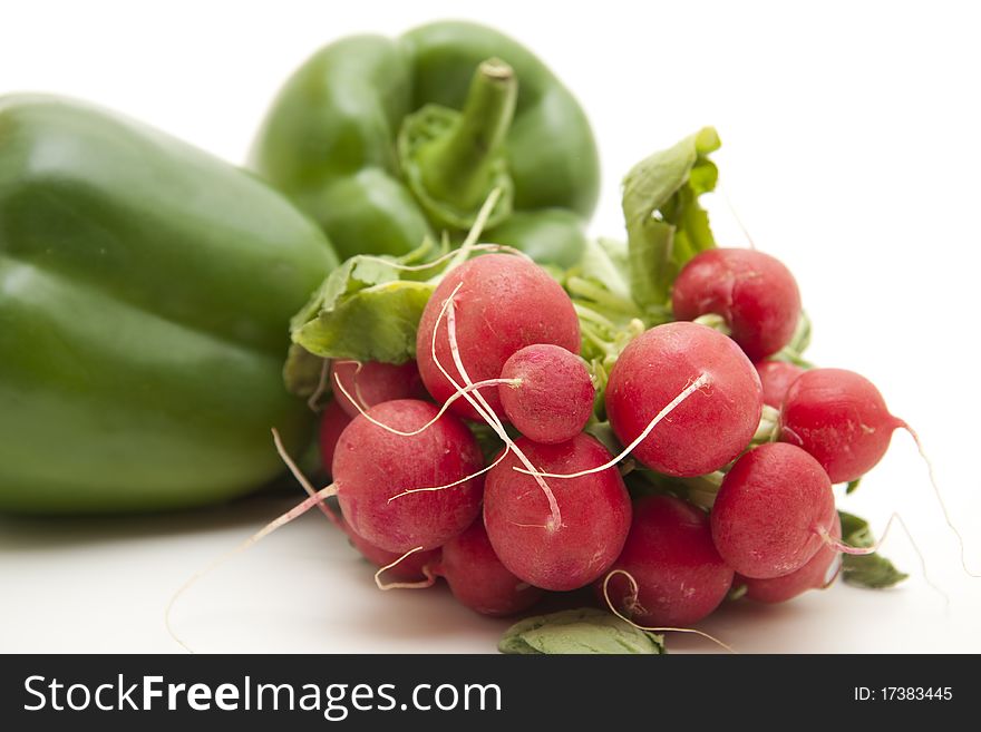 Radishes and paprikas onto white background