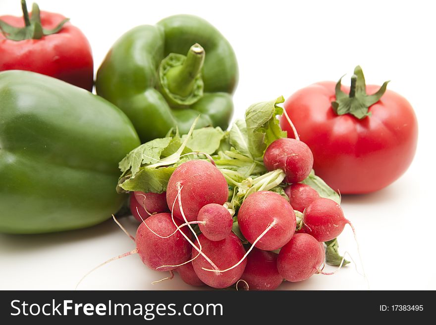 Radishes and paprikas onto white background