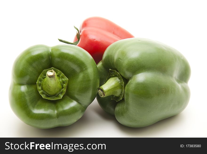 Greens and red paprikas onto white background