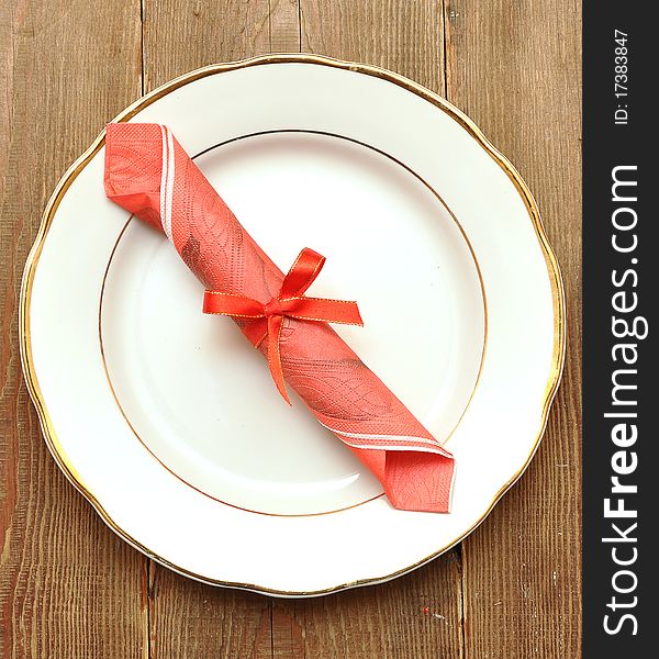 White plate and napkin on old wood background