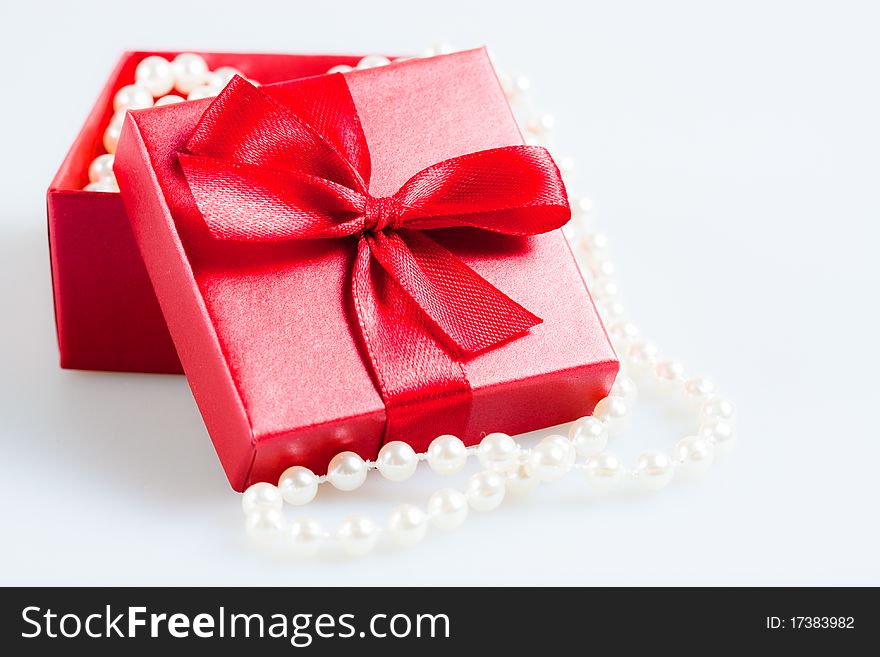 Gift with beads in the red packing on a white background