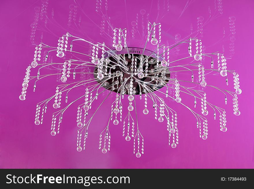 Graceful chandelier on a lilac ceiling at restaurant. Graceful chandelier on a lilac ceiling at restaurant.