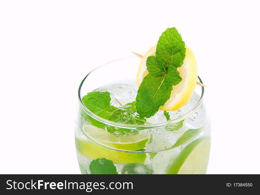 Mojito vacation cocktail without alcohol with lime, spring of mint, sprite soda and syrup in cocktail glass isolated on a white background. Mojito vacation cocktail without alcohol with lime, spring of mint, sprite soda and syrup in cocktail glass isolated on a white background