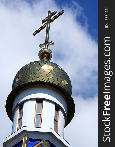 Dome with a cross of the Orthodox Church against the blue sky and clouds. Dome with a cross of the Orthodox Church against the blue sky and clouds