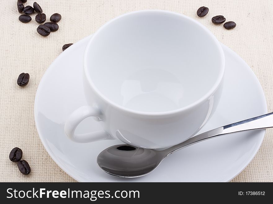 Empty ceramic cup with a saucer on a white background.