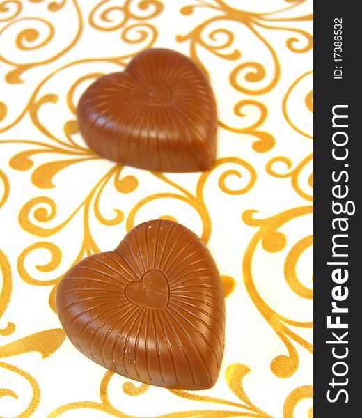 Mouthwatering chocolates in a heart-shaped on a colored background