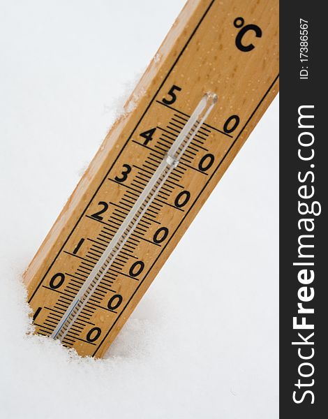 Wooden thermometer in the snow