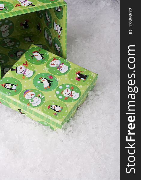 Green gift box for Christmas on a background of decorative snow.