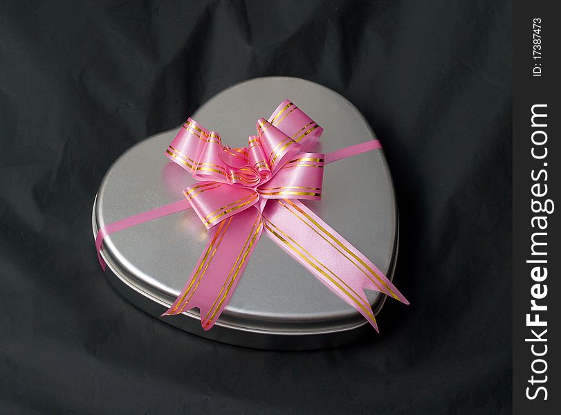 Gift box in the shape of a heart with a pink bow