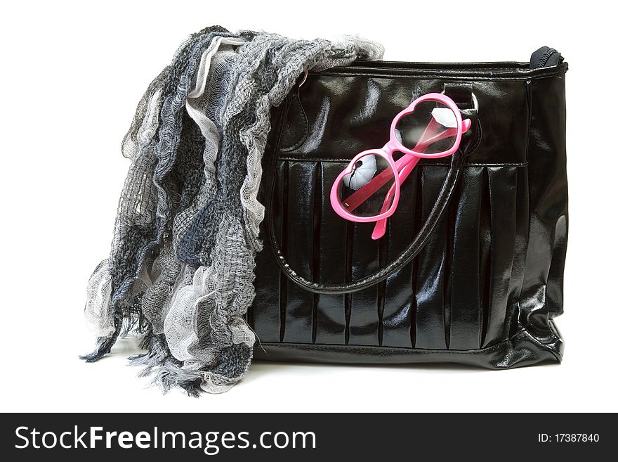 Feminine bag with scarf and rose-colored glasses on white background