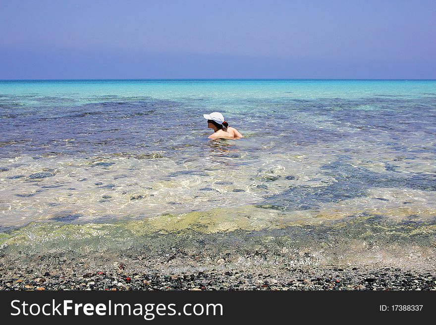 Young woman swimming at tropical island beach
