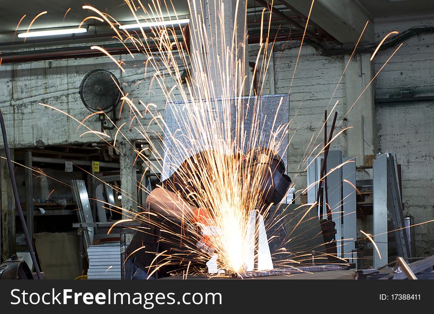 Sparks frying over the working table during metal grinding