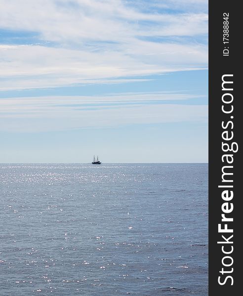 Blue sea. Ship on the horizon. Hot sunny summer day, beautiful clouds,