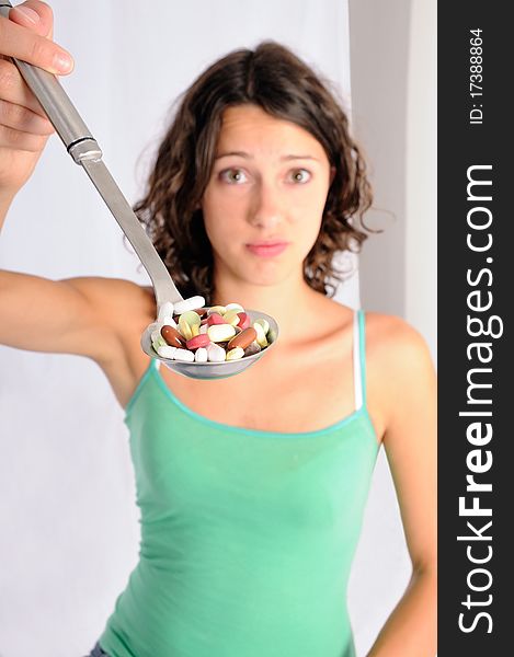 Shot of cute girl with spoon full of pills. Concept shot for alternative medicine. Shot of cute girl with spoon full of pills. Concept shot for alternative medicine