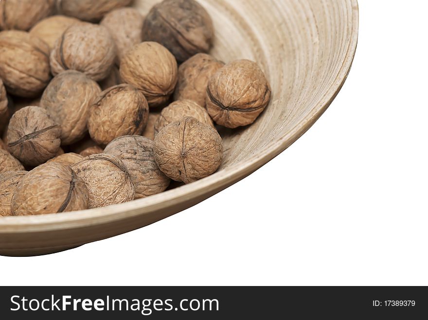 Isolated wooden bowl with walnuts