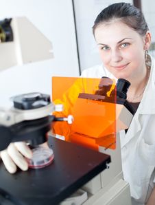 Pretty Female Researcher Using A Microscope Royalty Free Stock Photos