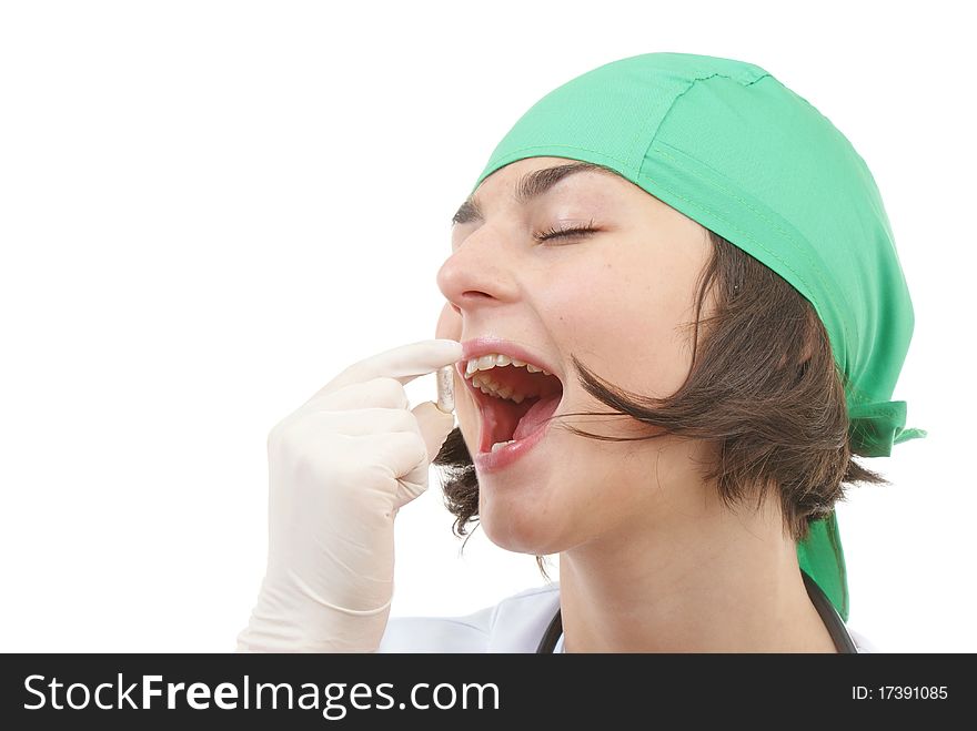 Attractive nurse eating pill isolated on white