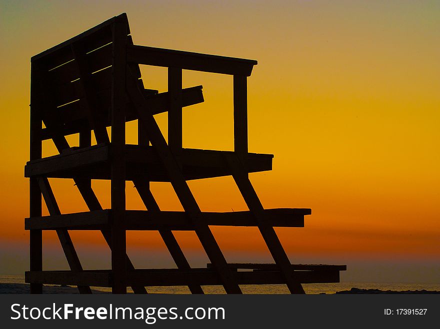 Lifeguard chair silhouette at dawn