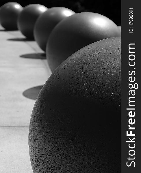 Large black balls forming a semi-circular curve concrete background. Large black balls forming a semi-circular curve concrete background