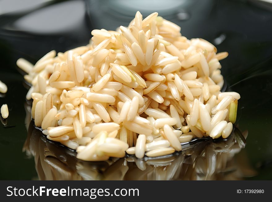 A pile of soaked brown rice on a black plate