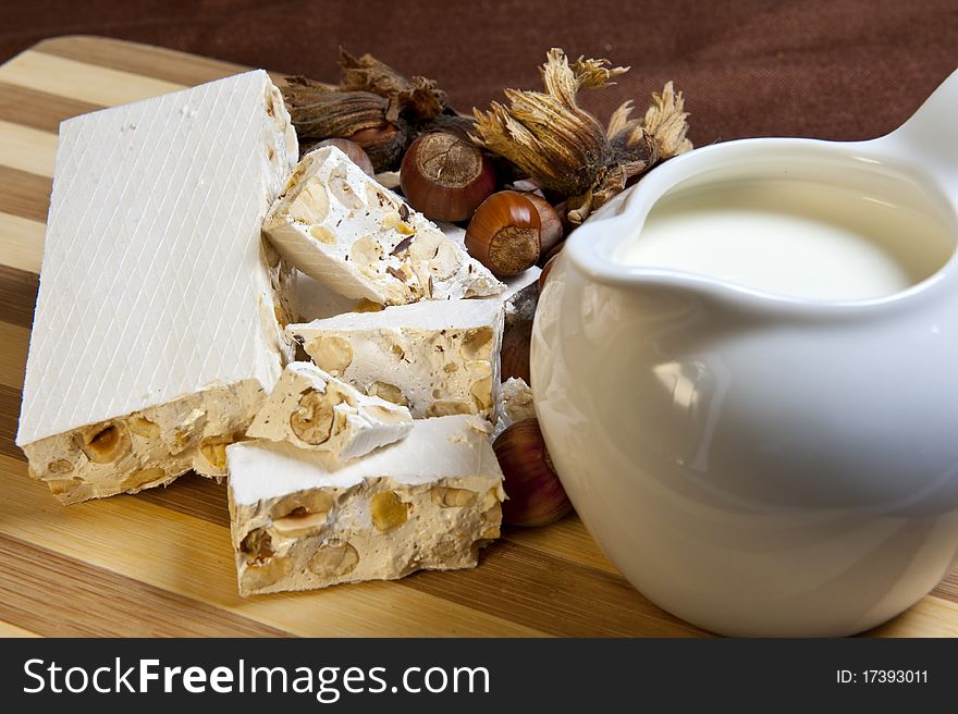 Nougat and hazelnuts on bamboo cutting board