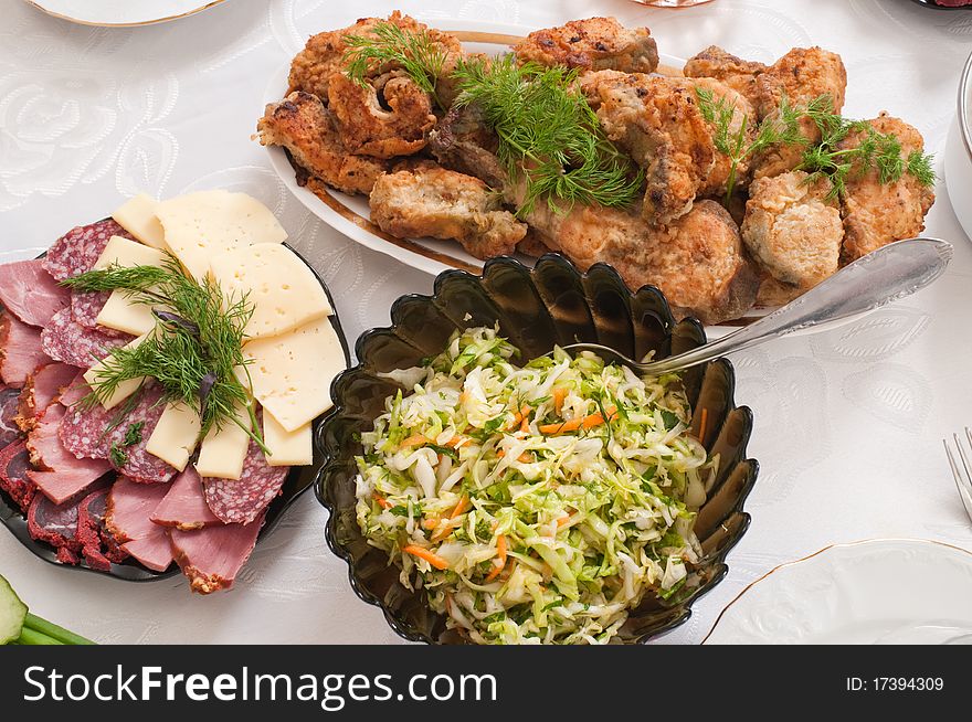 Fried fish and cabbage salad on a dining table. Fried fish and cabbage salad on a dining table.