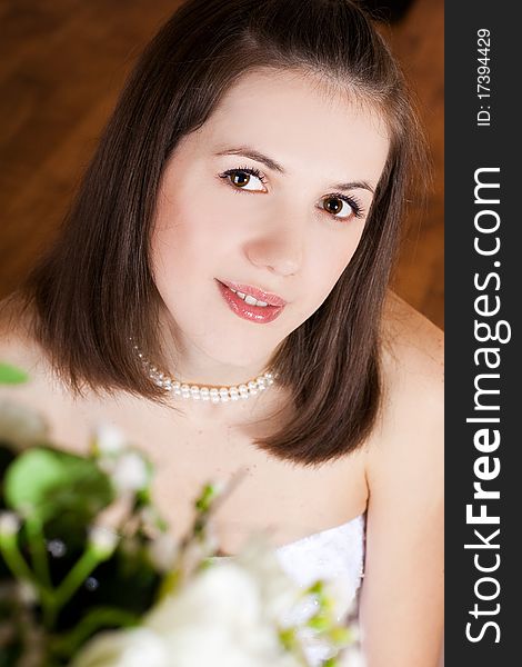 Studio portrait of beautiful stylish bride with flowers