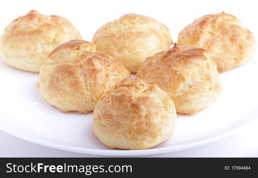 Six fresh baked homemade buns on a white plate. Shallow dof