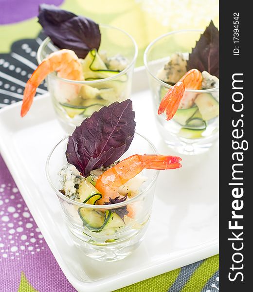 Tasty prawns appetizer with zucchini, cheese and basil in glass