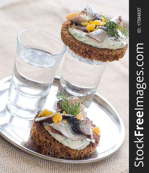 Anchovy canapes garnished with dill and yolk and vodka. Anchovy canapes garnished with dill and yolk and vodka