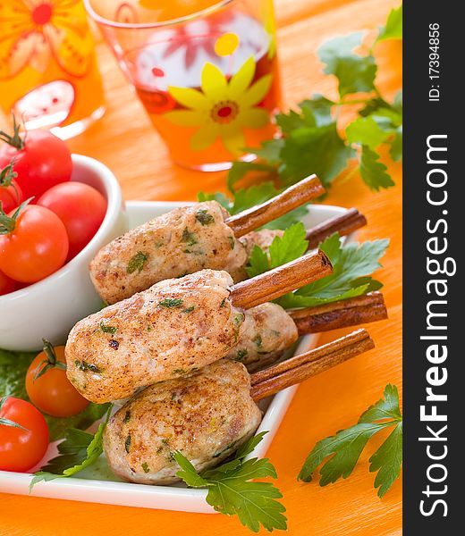 Pork (or chicken) kebab on cinnamon stickst with salad and tomatoes
