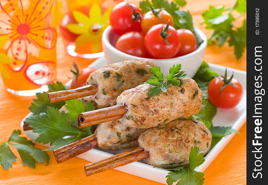 Pork (or chicken) kebab on cinnamon stickst with salad and tomatoes