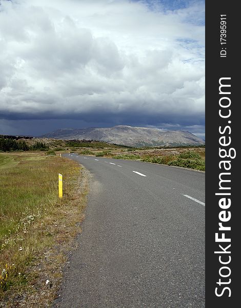 Road under stormy sky in Thingvellir National park in southwest Iceland