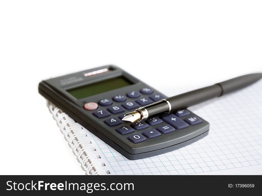 Fountain pen lying on calculator and spiral notebook isolated on white background. Fountain pen lying on calculator and spiral notebook isolated on white background