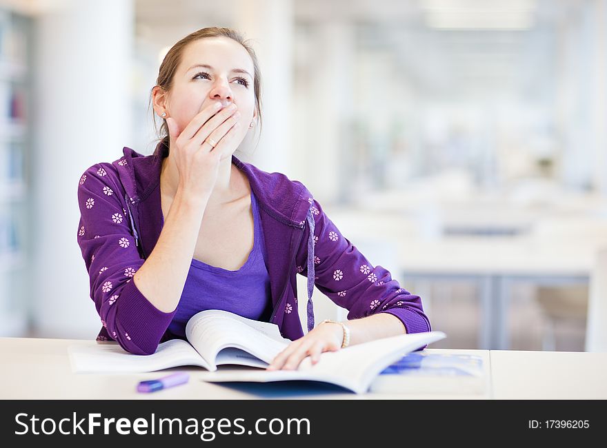 Pretty young college student in a library