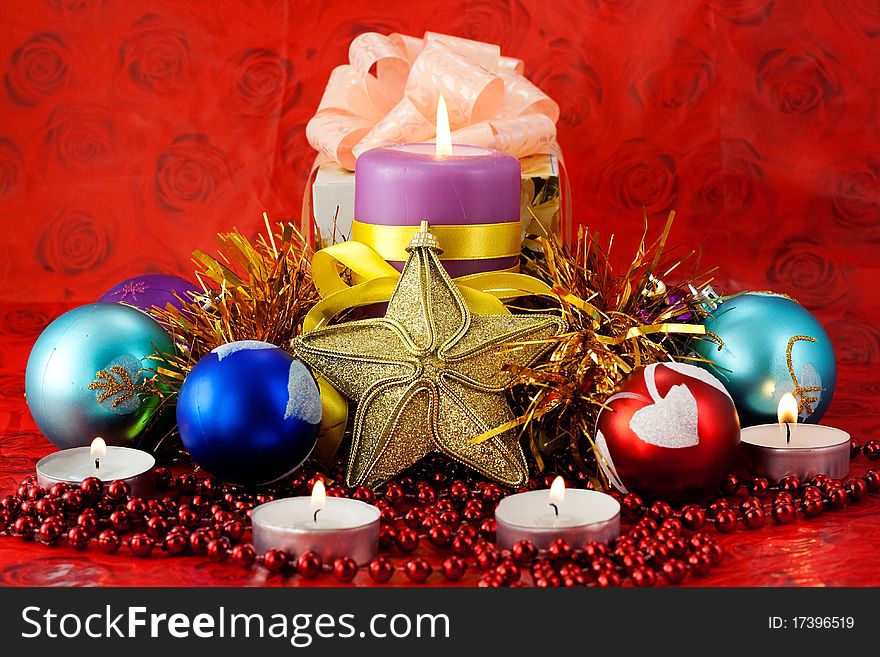 Christmas decorations and lighted candles on a red holiday background. Christmas decorations and lighted candles on a red holiday background