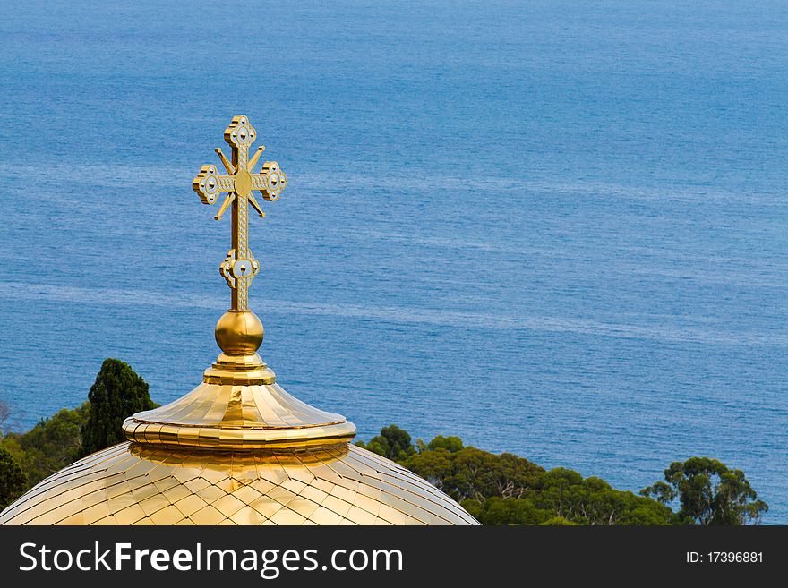 Golden dome of the Orthodox church with blue sea background
