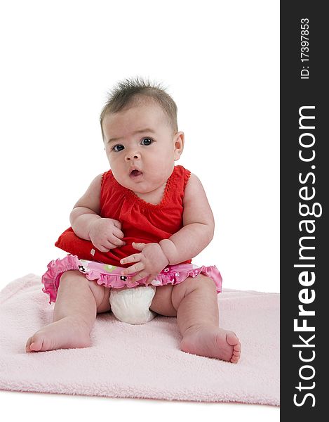 Cute asian-caucasian baby sitting on pink towel, isolated on white background