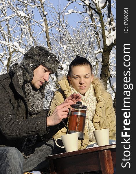Young man and woman preparing tea in winter season. Young man and woman preparing tea in winter season