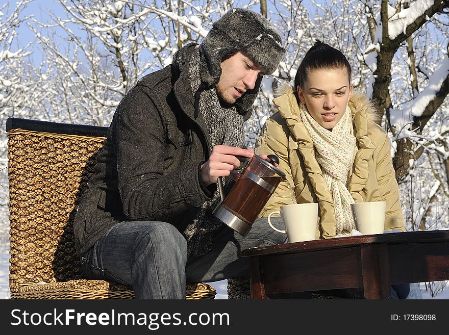 Teenager boy preparing hot tea for his girl friend in winter season. Teenager boy preparing hot tea for his girl friend in winter season