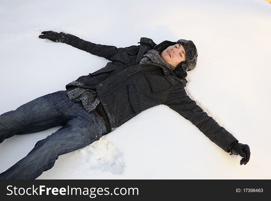 Young man creating angels in winter season. Young man creating angels in winter season