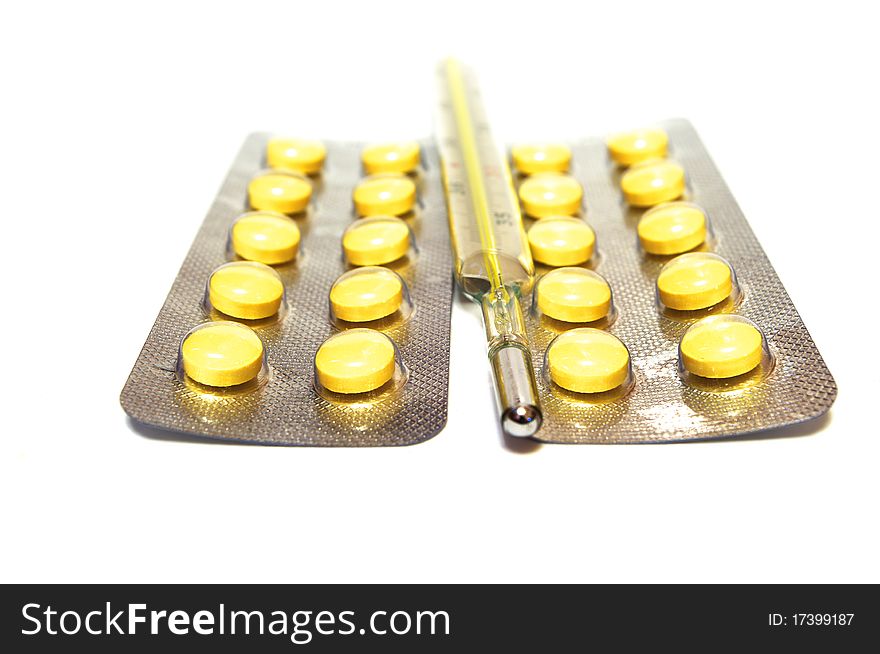 Photo of the thermometer and pills on white background