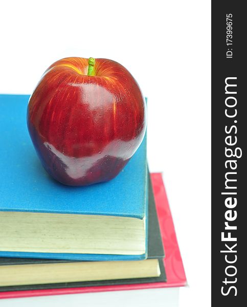 Red apple and books isolated on white. Red apple and books isolated on white