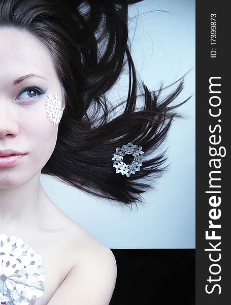 Portrait of young girl with makeup and cut snowflakes