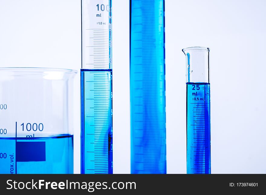 Laboratory test equipment with blue liquid inside on white background