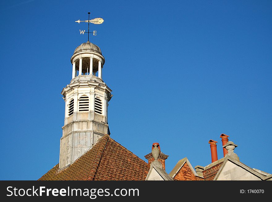 weather-vane on top of a tower pointing west. weather-vane on top of a tower pointing west
