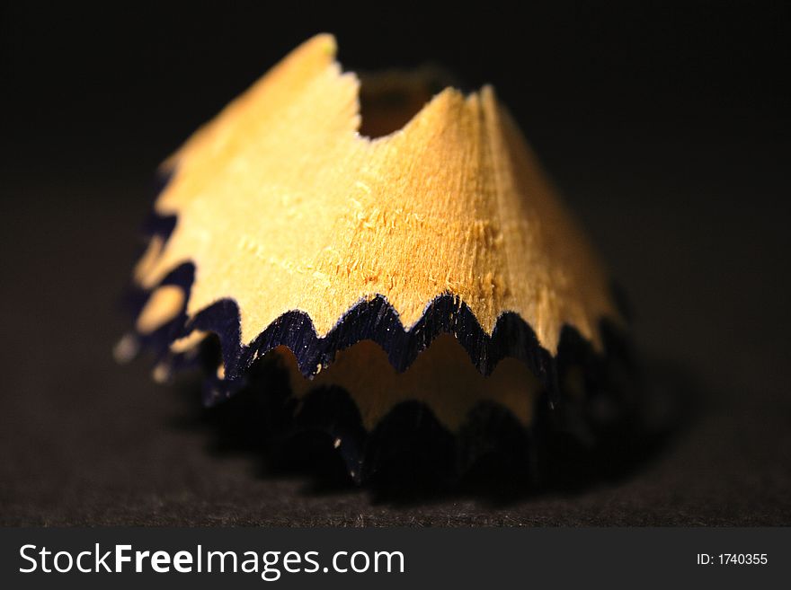 Black crayon spiral macro photo with black background.