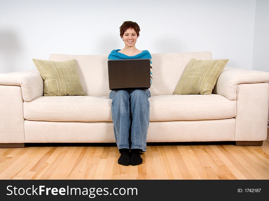 Woman on her laptop sitting on the sofa